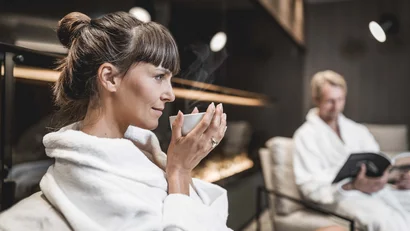 Woman in bathrobe drinking hot tea in a relaxing setting