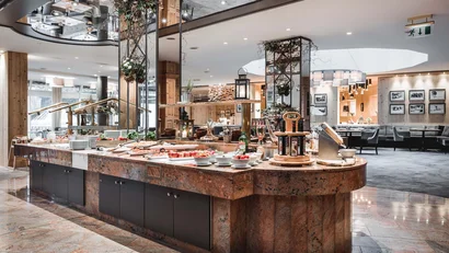 Modern restaurant buffet with greenery-decorated mirrors