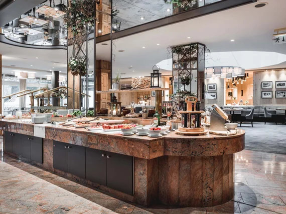 Modern restaurant buffet with greenery-decorated mirrors