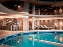 Indoor pool view in a modern spa with lounge chairs and warm lighting