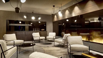 Modern lounge area with fireplace and comfortable chairs in wood setting