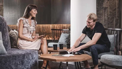 Two people sitting in living room looking at a book together