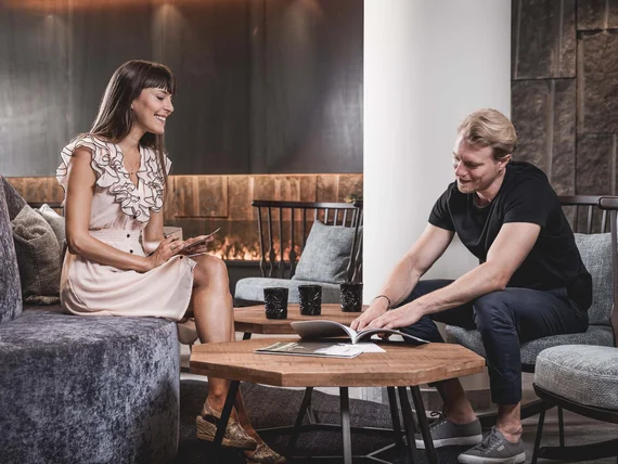 Two people sitting in living room looking at a book together