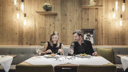 Couple dining in cozy restaurant with wooden walls and hanging lights