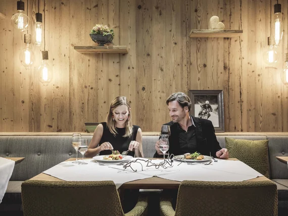 Couple dining in cozy restaurant with wooden walls and hanging lights