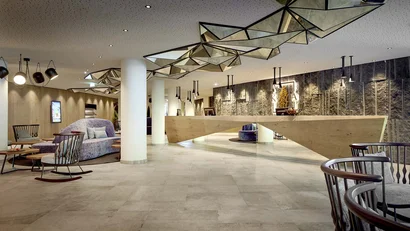 Modern hotel lobby with geometric mirror ceiling lights and seating area