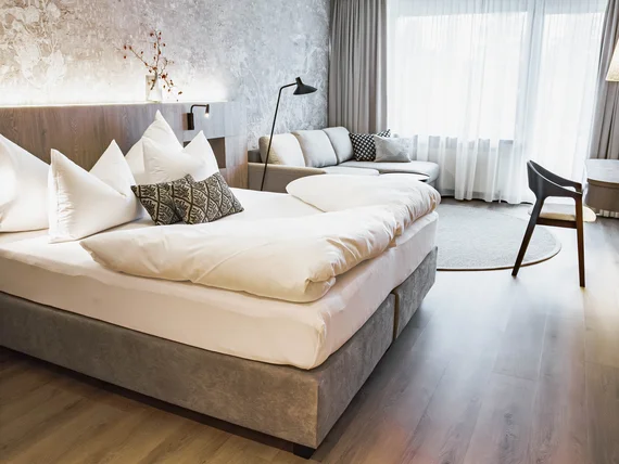 Bright modern hotel room with cozy bed and sofa