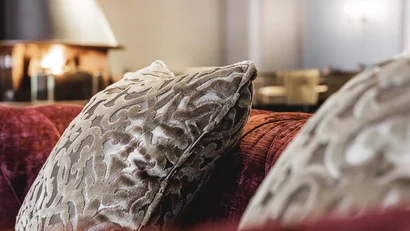 Patterned pillows on red sofa near fireplace in living room