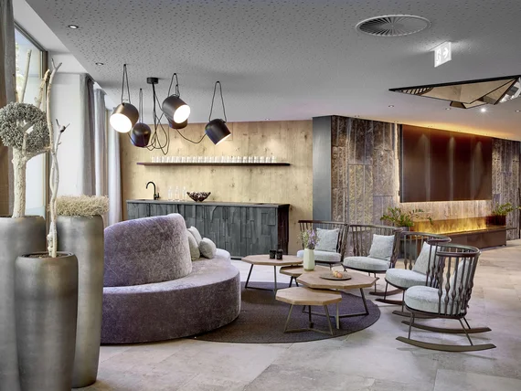 Modern lounge with gray sofa, armchairs, and hanging lamps