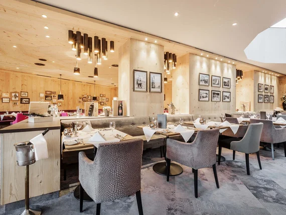 Modern restaurant interior with wooden walls and set dining tables